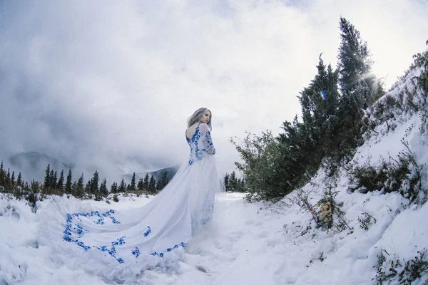 Piękna panna młoda w śniegu w górach — Zdjęcie stockowe