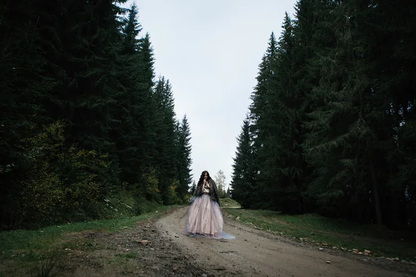 Portret van romantische vrouw in mooie jurk in bos — Stockfoto