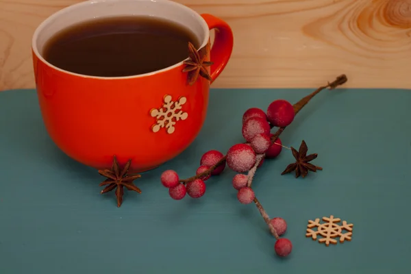 Cristmas theme - big orange tea cup and cinnamon roll — Stock Photo, Image