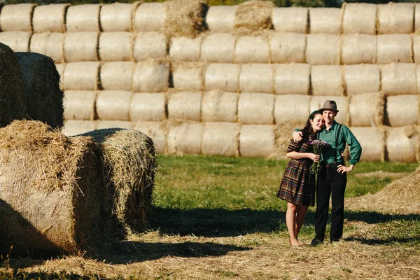 Homem e mulher abraçando em um campo — Fotografia de Stock