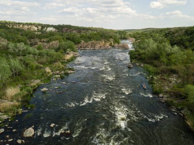 Granit dağlara ve üzerinde kano ve turist olan Güney Böcek nehrine açılan hava manzarası, Mihiia köyü. Ukrayna. Rafting ve kano yapmak için ünlü bir yer.