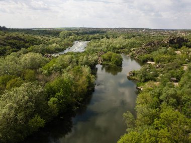 Granit dağlara ve Güney Böcek nehrindeki akıntılara, ağaçlar ve otlarla çevrili Mihiia köyüne hava manzarası. Ukrayna. Rafting ve kano yapmak için ünlü bir yer.