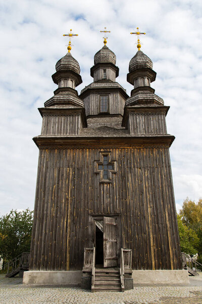 Ancient famous wooden Cossacks Tserkva (St.George's Church) in Ukrainian village Sedniv near Chernihiv. Architectural tradition of Eastern Europe. Typical village in Ukraine