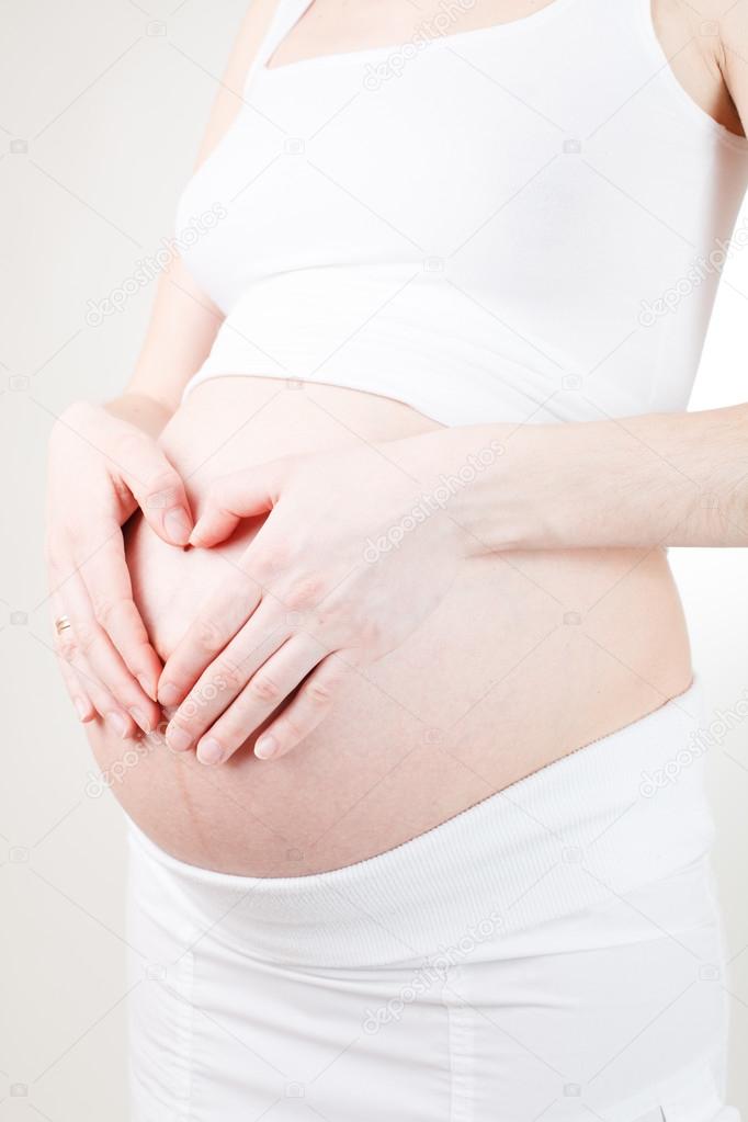 pregnant woman holding her belly arms