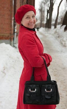 Sokakta kışın giyinmiş güzel olgun bir kadın.