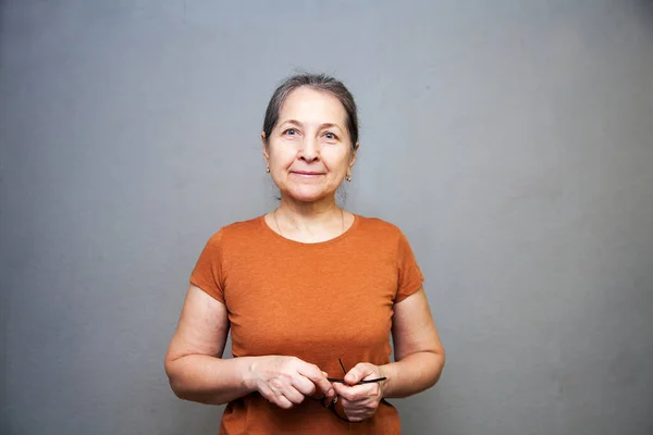 Kameraya bakan mutlu, yaşlı bir kadının yakın plan portresi.