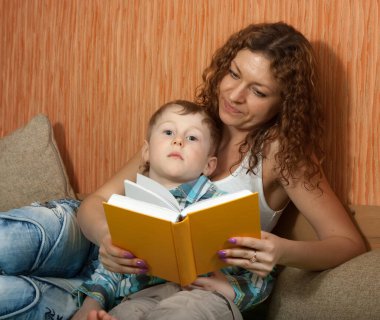 Mutlu anne ve oğlu kanepede oturuyor.