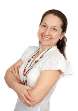 Beyaz arka planda duran gülümseyen olgun bir kadının portresi