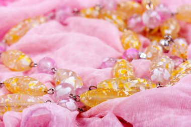 Pembe kumaş üzerinde renkli taşlar.