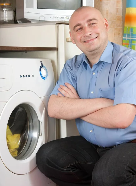 Man with washing machine at his home