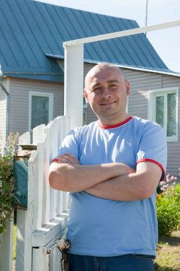 Evinin önünde gülümseyen adam. Kalenin yanında.