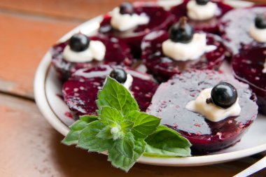 Böğürtlenli tatlı beyaz tabakta, ahşap masada.