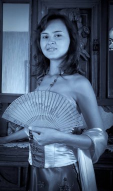 Eski model bir dairede poz veren göz kamaştırıcı güzellikteki genç bir kadının moda fotoğrafı. 