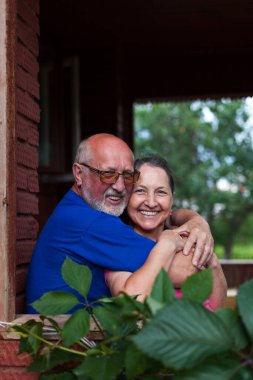 Sevimli yaşlı erkek ve kadınların portresi kır evinin verandasında.. 