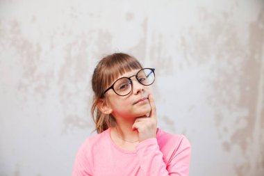   8 yaşında, arka planda gözlüklü bir kız..