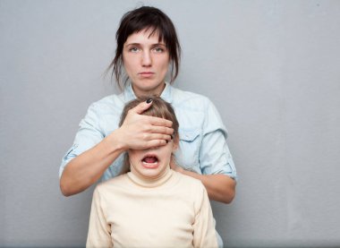 Korkmuş 8 yaşındaki bir çocuğun gözlerini kapatan bir kadın. Çocuk ve ebeveynlik eğitimi sorunları