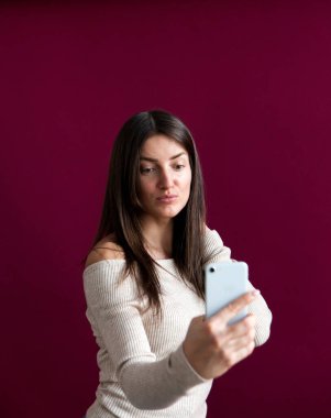 Bej ceketli ve kot pantolonlu manken arka planda selfie çekiyor