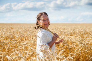   Rus yaşlı kadın buğday tarlasında yürüyor. 