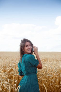 Beautiful model girl in   green long dress in nature