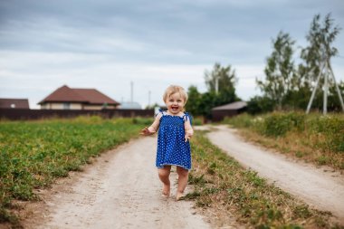 Köy yolunda çıplak ayakla bir yaşındaki bir bebeğin portresi.