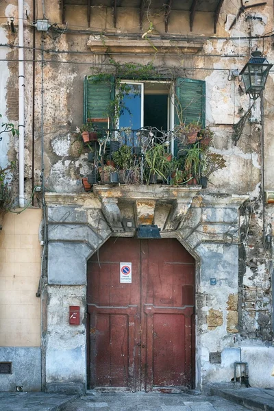 Vintage balkon s různými květy, popraskané omítky a dřevěné dveře, středomořském stylu Stock Fotografie