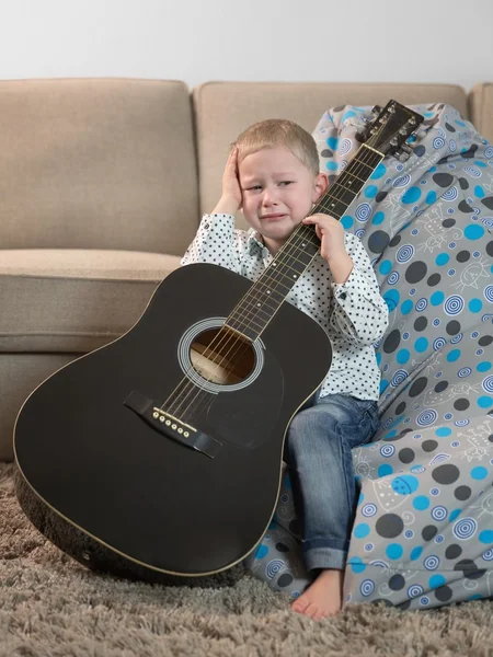 Weinender Junge mit Gitarre in der Hand — Stockfoto