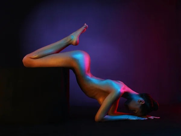 Elegante modelo desnudo en los proyectores de colores claros —  Fotos de Stock