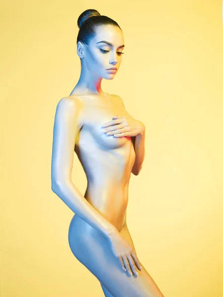 Elegante modello nudo sotto i riflettori di colore chiaro — Foto Stock