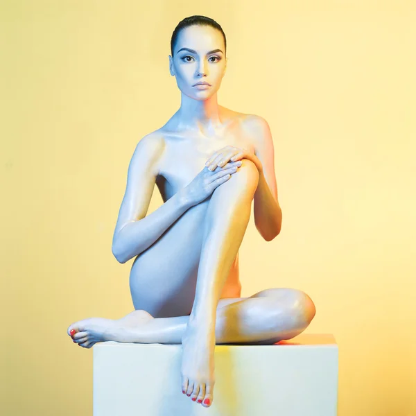 Elegant nakenmodell i de ljusa färgade spotlights — Stockfoto