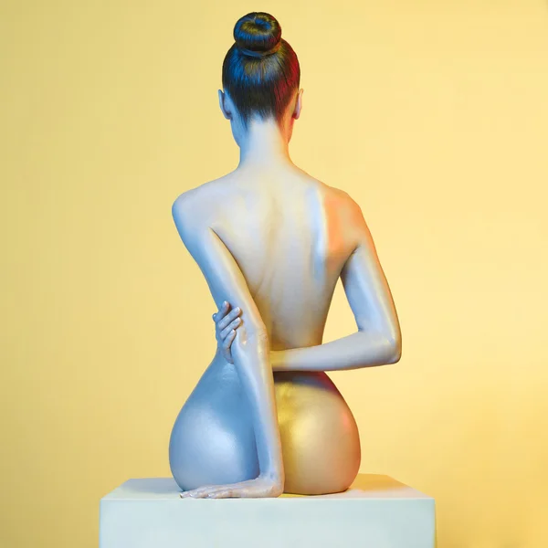 Elegante modelo desnudo en los proyectores de colores claros — Foto de Stock