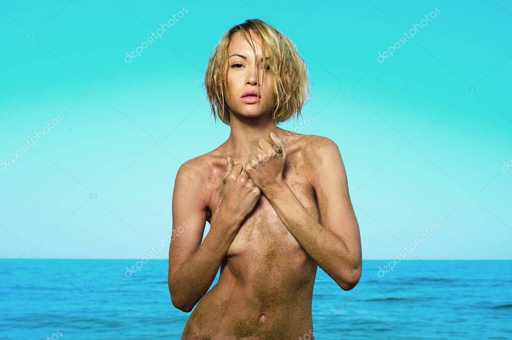Beautiful nude woman  with nice tan on the beach. Travel photo of exotic seashore.