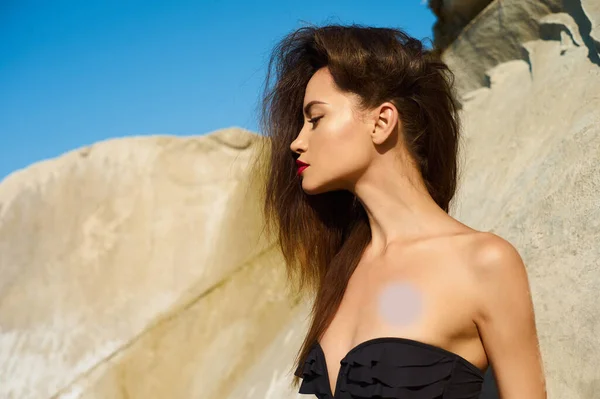 美しいエレガントな女性は黒の水着でビーチでポーズ 海の上のセクシーなブルネット — ストック写真