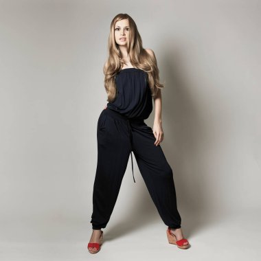 Çekici dansçı kızın portresi. Gri arka planda güzel bir bayan. Siyah elbiseli güzel kadın.