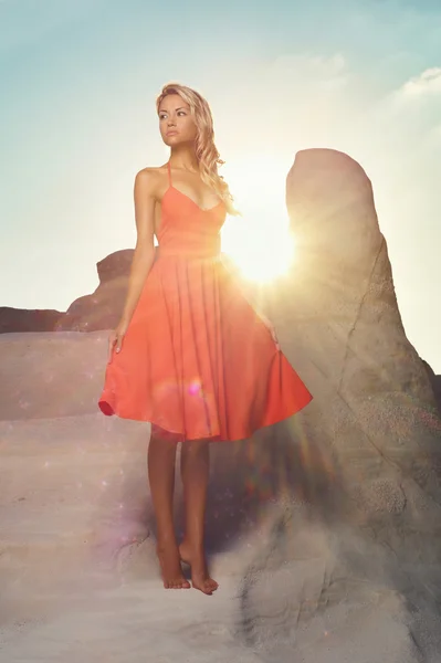 Леди в красном платье в необычном пейзаже — стоковое фото