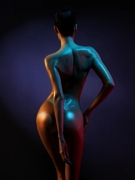 Elegante modelo desnudo en los proyectores de colores claros — Foto de Stock