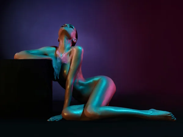 Elegante modelo desnudo en los proyectores de colores claros — Foto de Stock