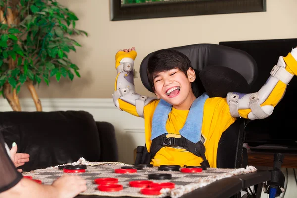 Unga funktionshindrade pojke i rullstol spelar pjäser — Stockfoto