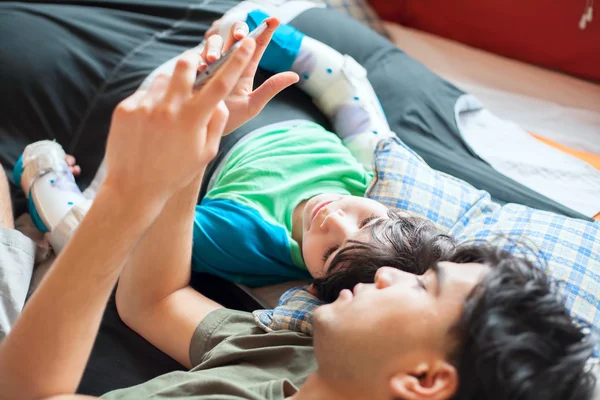 Teen  on floor using computer tablet with disabled little  boy — Stock Photo, Image