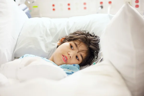 Disabled little boy lying sick in hospital bed — Stock Photo, Image