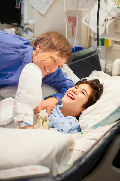 Ο πατέρας βλέποντας πάνω γιο με ειδικές ανάγκες στο κρεβάτι του νοσοκομείου — Φωτογραφία Αρχείου