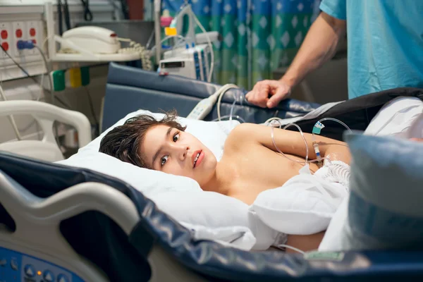 Deficiente menino de nove anos deitado doente na cama do hospital — Fotografia de Stock