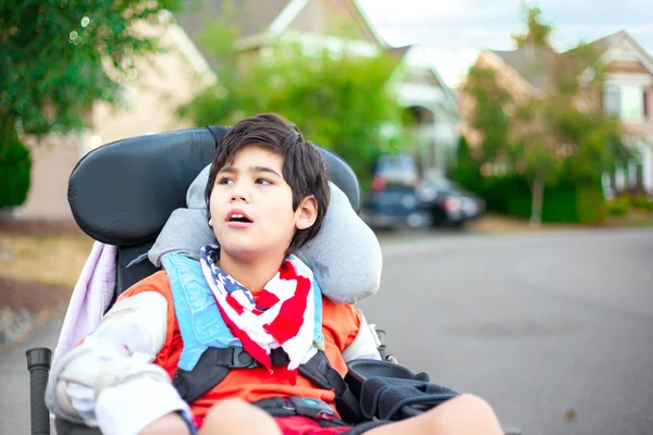 Unga funktionshindrade pojke i rullstol tittar upp i himlen — Stockfoto