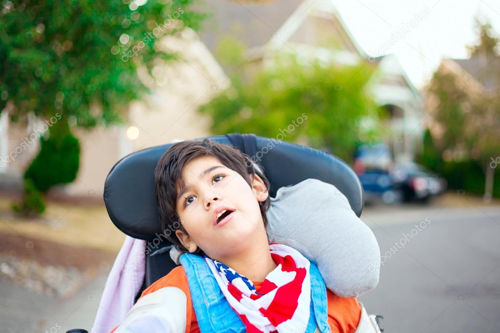 Young disabled boy in wheelchair looking up into sky