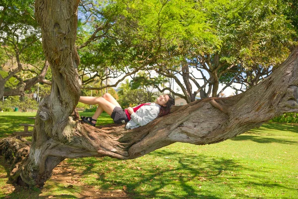 Dwurasowa Nastolatka Dziewczyna Odpoczywająca Dużym Gniecionym Skręconym Drzewie Gałęzi Dużego — Zdjęcie stockowe