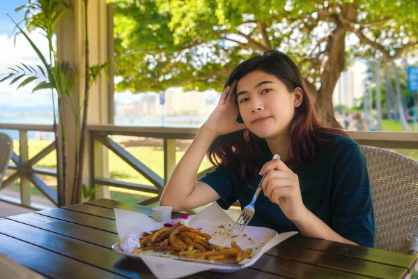 若いです10代の女の子食べるフランス語フライドポテトで屋外レストラン近くの海でハワイ — ストック写真