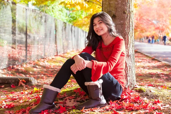 Sorrindo Menina Adolescente Birracial Camisa Vermelha Sentado Sob Folhas Outono — Fotografia de Stock