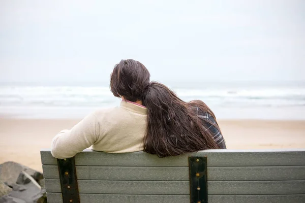 在多雾的日子里 一对年轻夫妇坐在海边的长椅上 坐在一起的背影 — 图库照片