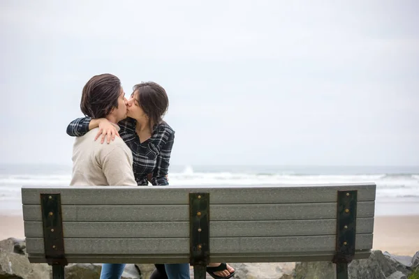 Young Biracial Couple Sitting Together Bench Beach Ocean Foggy Day — Stock Photo, Image