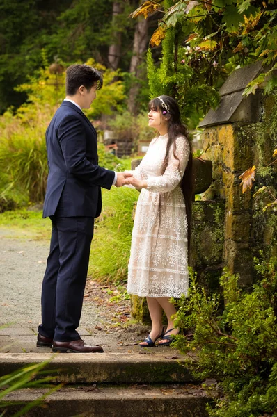新娘和新郎手牵手 用石墙举行户外婚礼 — 图库照片