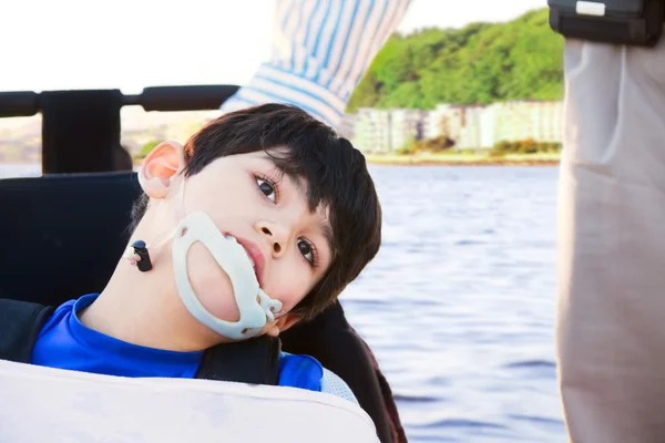 Niño discapacitado en silla de ruedas junto a su padre — Foto de Stock